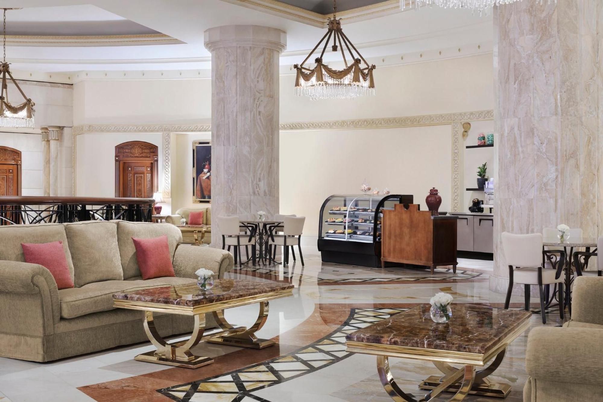 Hotel Intercontinental Dar Al Iman Madinah By Ihg Medína Exteriér fotografie The image shows a spacious and elegantly designed hotel lobby or lounge area. It features plush sofas with cushions, stylish coffee tables, and decorative elements. The decor includes marble columns and a chandelier hanging from the ceiling, adding t